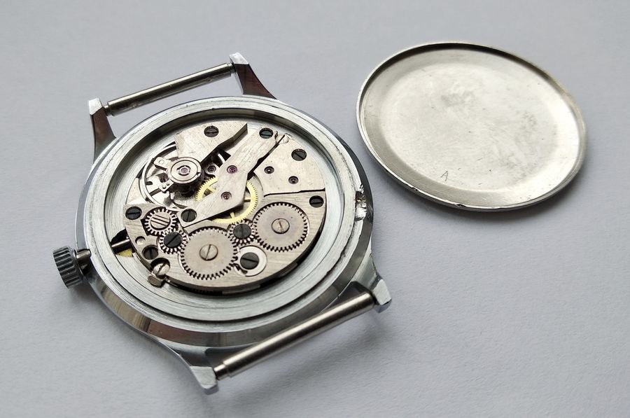Movement exposed showing late-period black screws