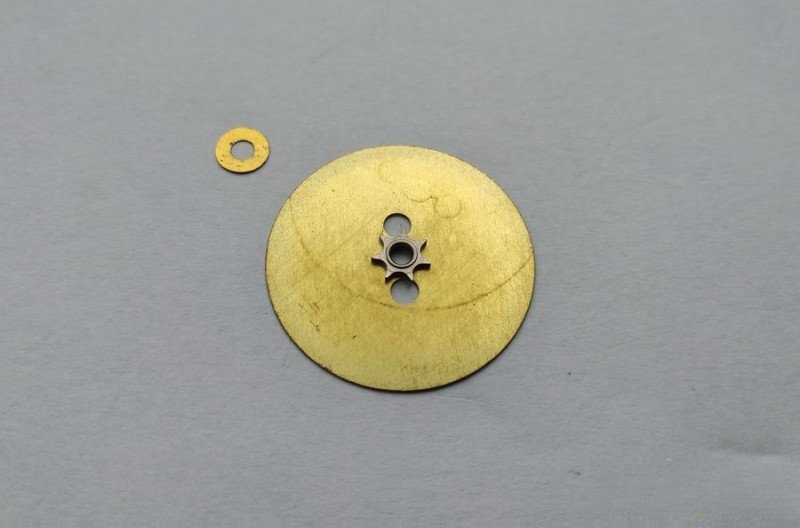 Reverse side of day-of-week disc showing seven-tooth wheel