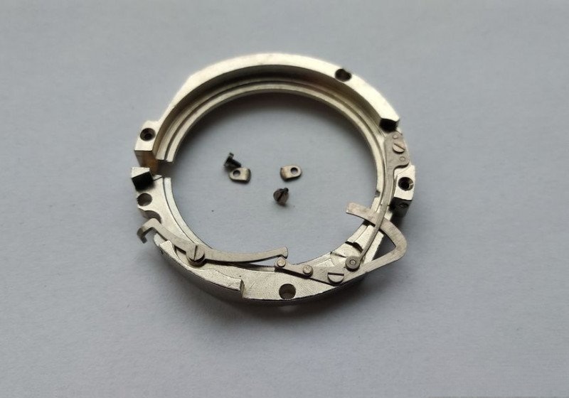 Date correction mechanism housing with mounting hardware