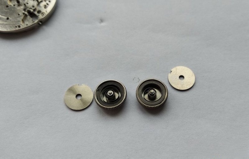 Mainspring barrels opened showing dirty, dry springs