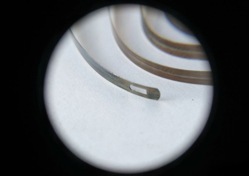 Alarm spring tail with friction device slot
