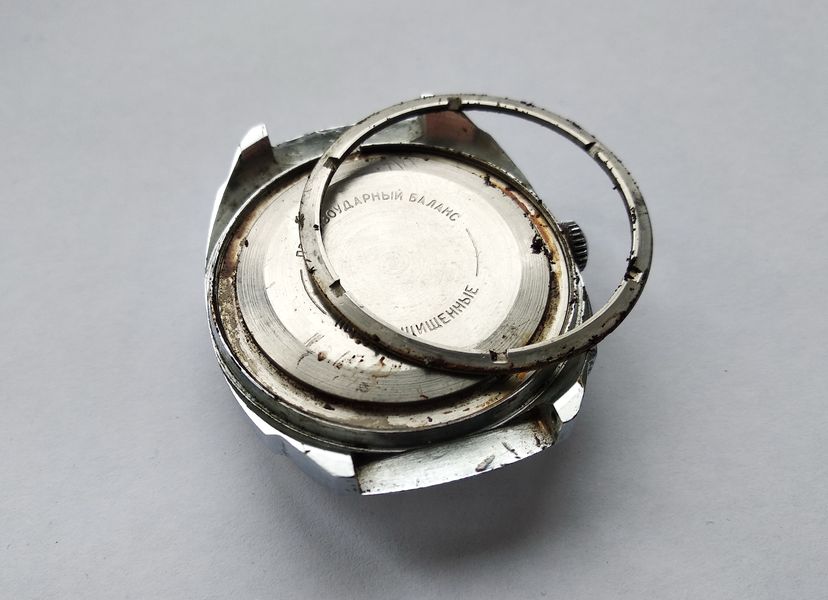 The loosened retaining ring lifted from the case revealing accumulated dirt in the thread