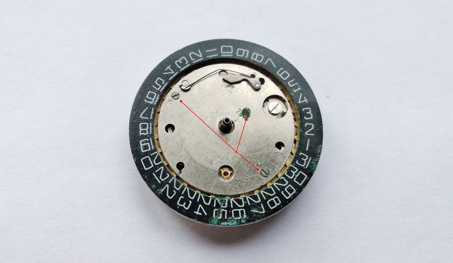Removing the day-disc support plate by undoing three screws marked with red arrows