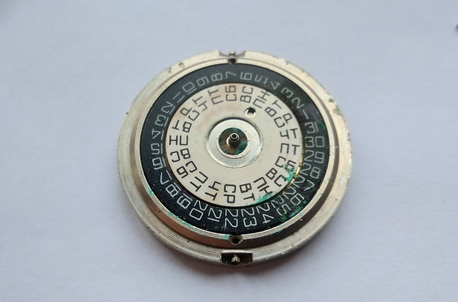The calendar discs revealed under the removed dial, one printed black on white and the other white on black