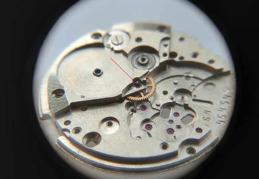 The seconds pinion exposed under the removed hook lever