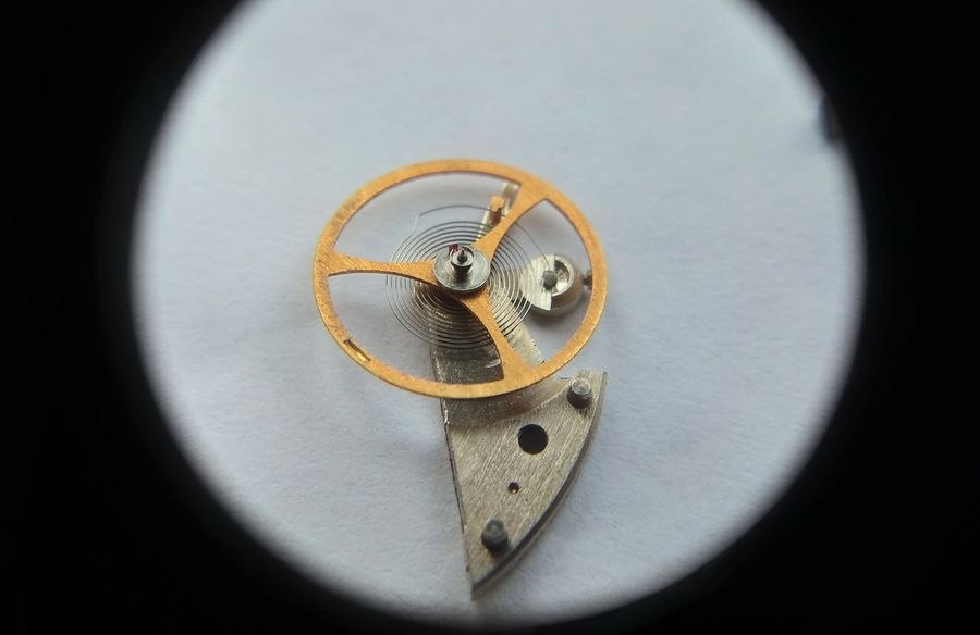 Top-down magnified view of the balance with its flat hairspring and regulator