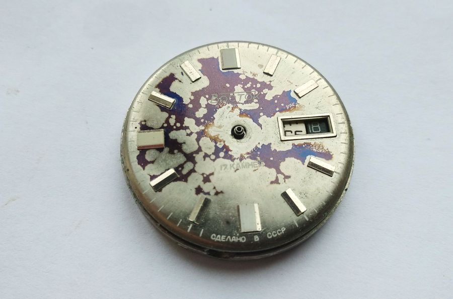 The stained dial about to be lifted from the movement