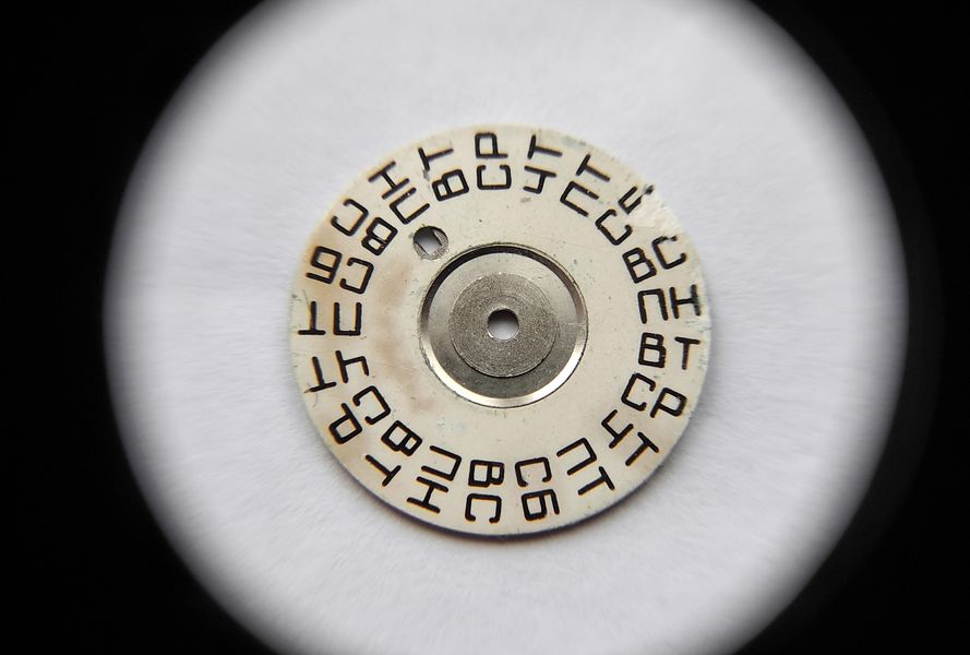 Installing the day-of-week disc, its sequence printed three times around