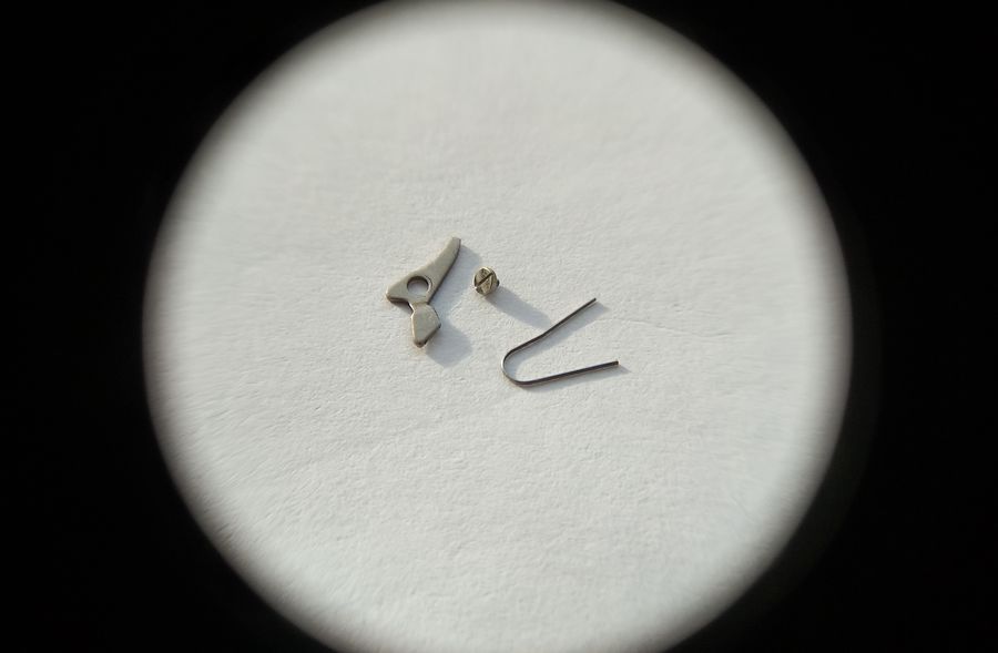 The disassembled parts of the date-disc detent mechanism