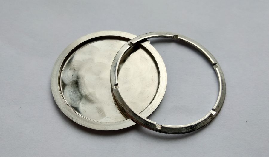 The cleaned case back and carrying ring after scrubbing