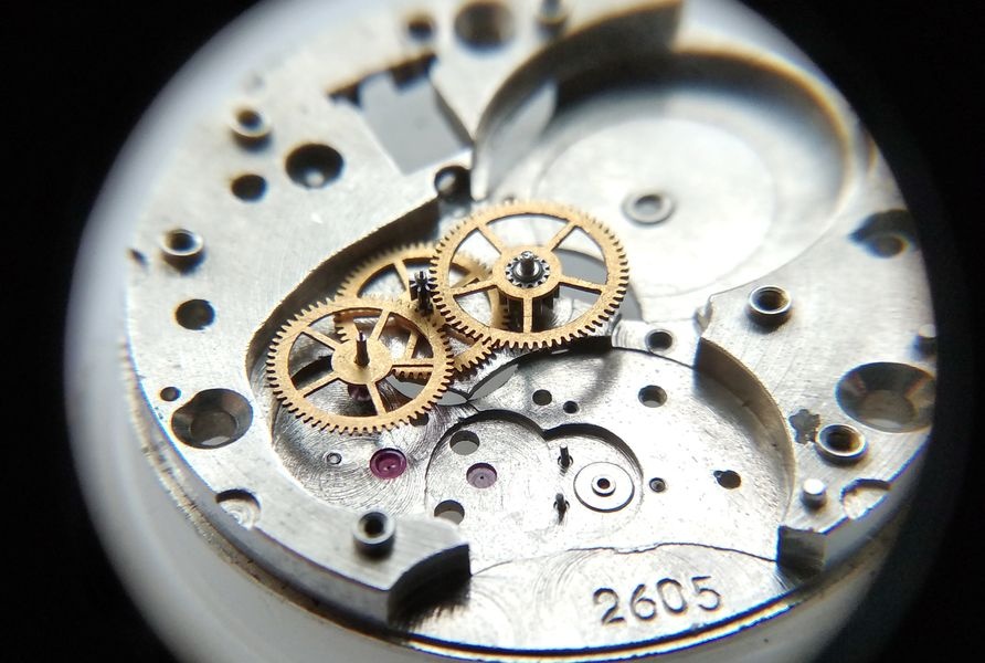 Vostok 2605 movement dial side through loupe with seconds wheel long pivot being directed into its jewel seat