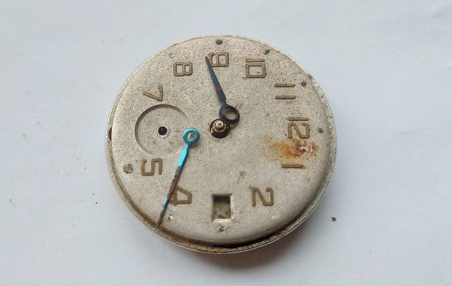 Vostok watch dial face with hands removed showing date window at three o'clock and sub-seconds opening at six