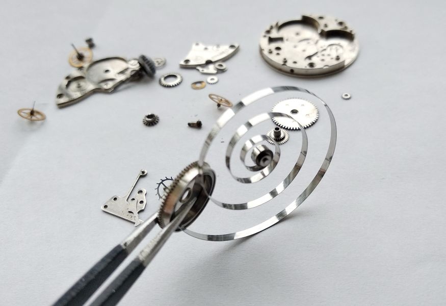 Vostok 2605 mainspring being installed into barrel showing spring shining in sunlight