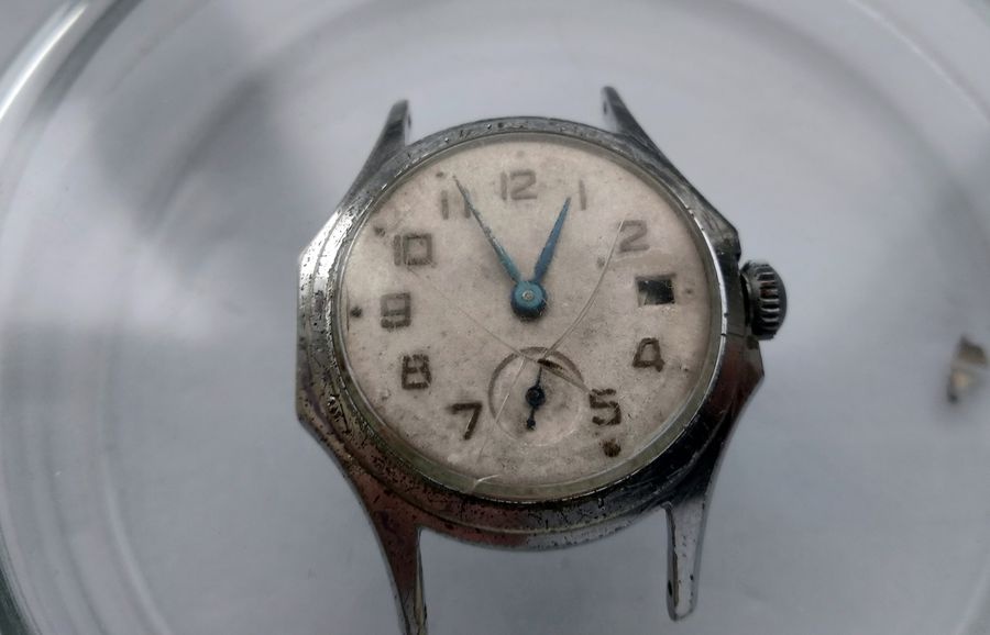 Vostok watch final condition from front showing aged dial blue steel hands running sub-seconds and empty date aperture without crystal