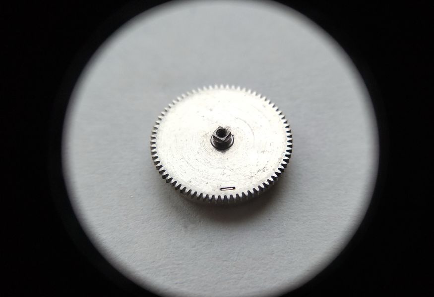 Vostok 2605 barrel through loupe from arbor side showing sword-shaped cover tabs seated in their slots