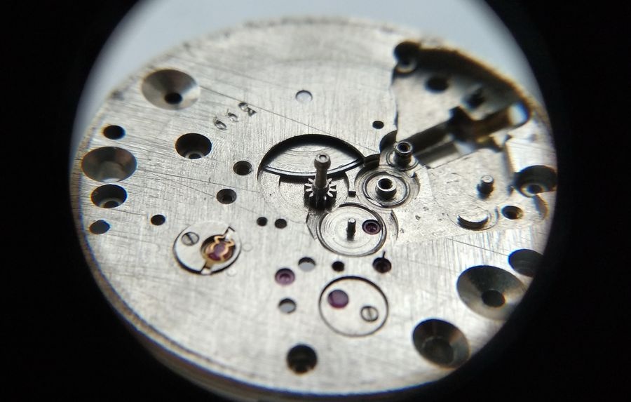 Vostok 2605 dial side through loupe with cannon pinion fitted and secured on center wheel shaft
