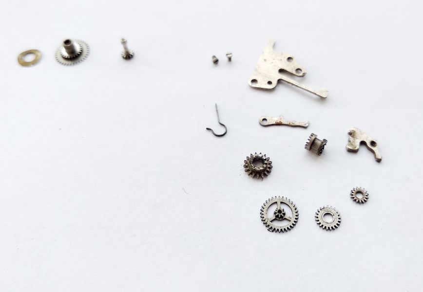 Vostok 2605 all keyless works components laid out in pieces on workbench