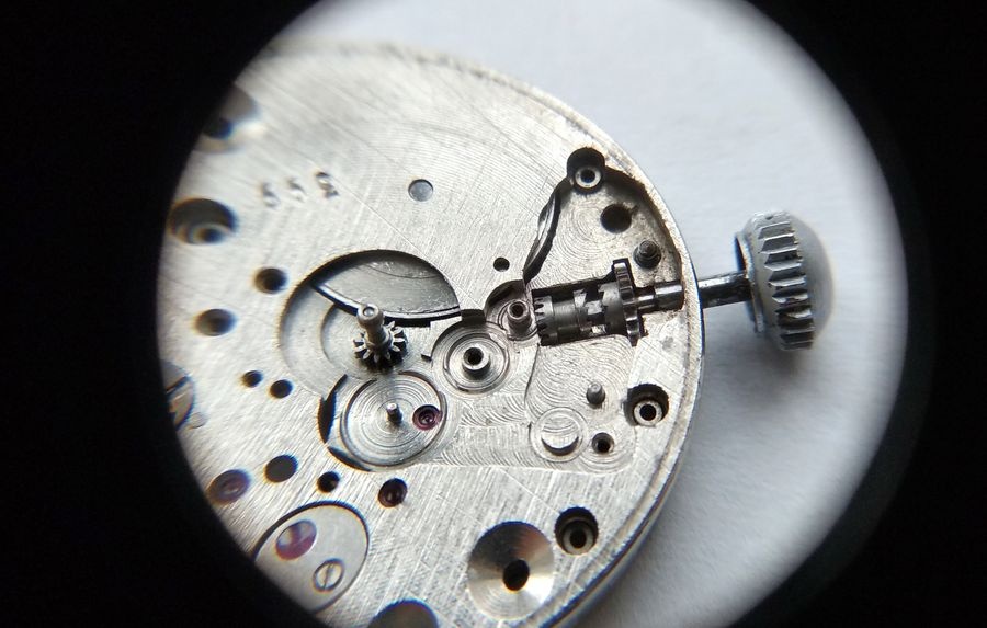 Vostok 2605 dial side through loupe with winding pinion cam coupling and stem installed and intermediate wheel jewel being lubricated