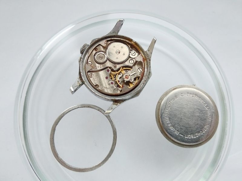 Vostok watch case opened showing rust at gasket seat with caseback and threaded retaining ring set aside
