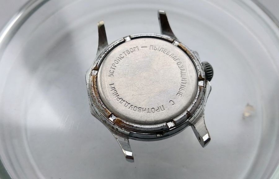 Vostok watch caseback closed showing Russian inscription confirming dust moisture resistance and anti-shock protection after service