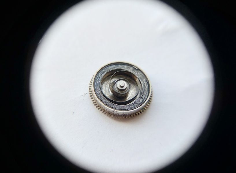 Vostok 2605 barrel opened through loupe showing mainspring coiled inside with dirt and degraded lubricant