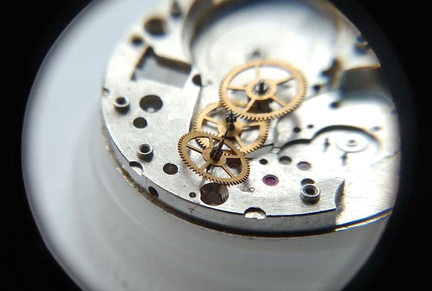 Vostok 2605 movement dial side through loupe showing seconds wheel with its characteristically long pivot in main plate