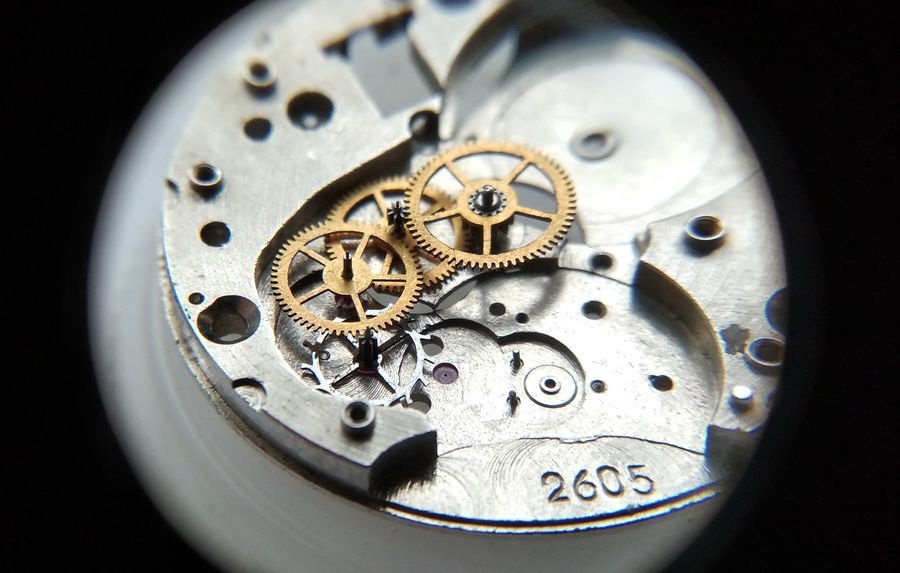 Vostok 2605 movement dial side through loupe with escape wheel placed last completing the full going train