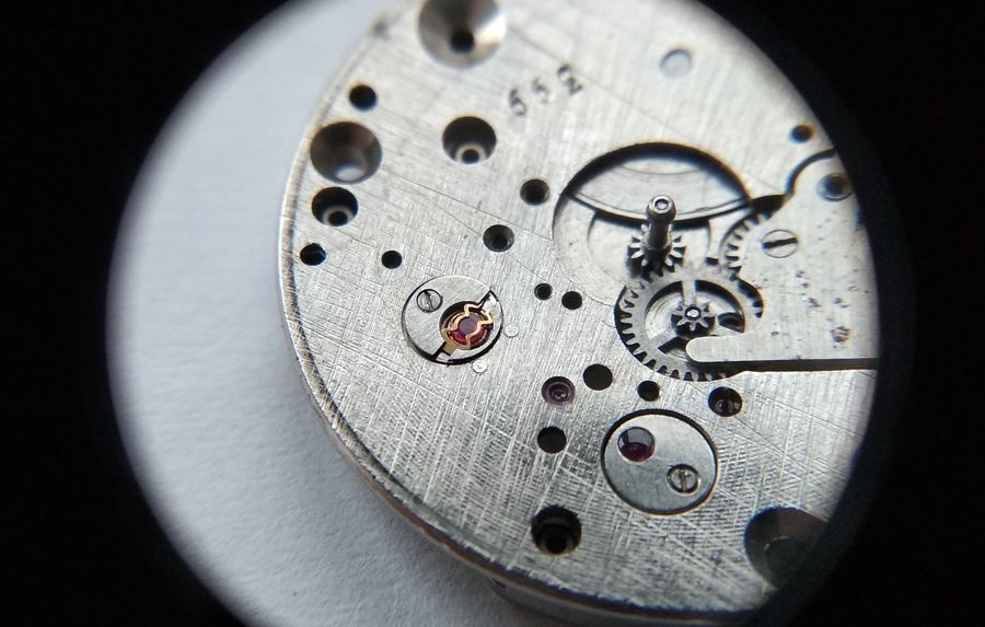 Vostok 2605 dial side through loupe with lyre spring tips locked securing the bouchon in the main plate