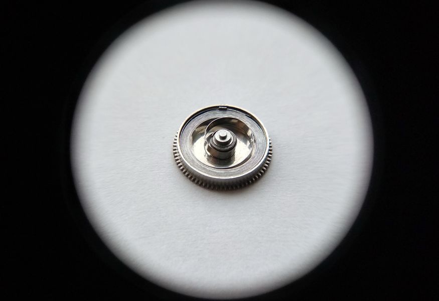 Vostok 2605 barrel through loupe showing mainspring coiled inside after lubrication before cover installation