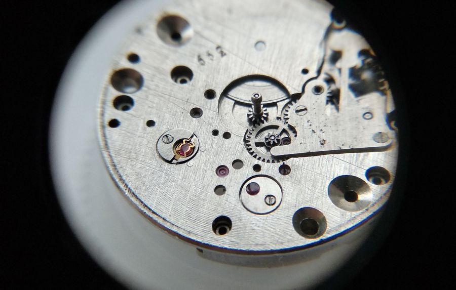 Vostok 2605 dial side through loupe showing overlay jewel returned to keyless works cover with dark lubrication circle clearly visible