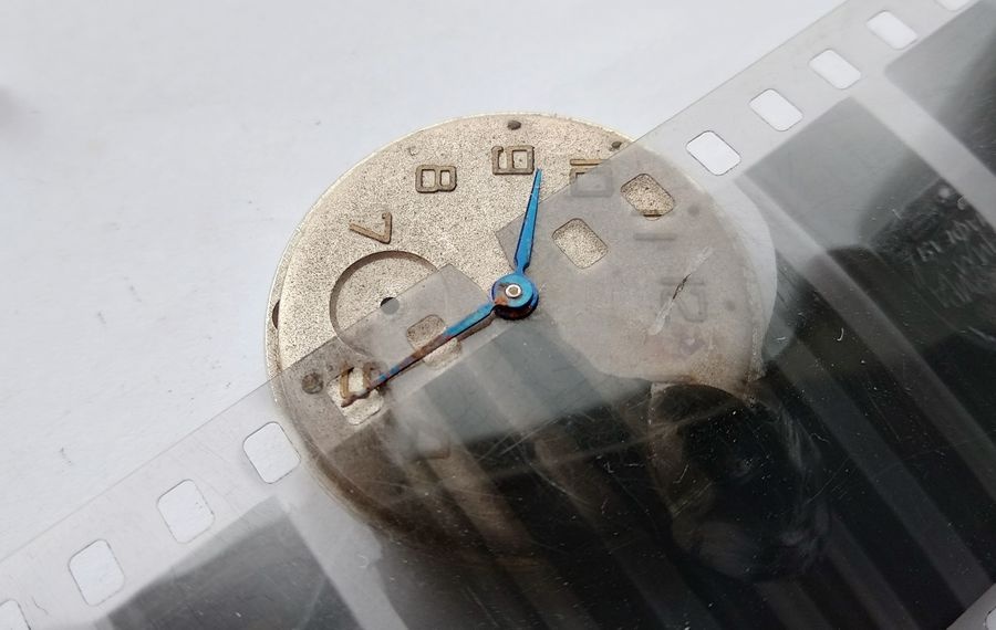 Vostok watch dial with hands photographed on 35mm film strip backdrop before hand removal