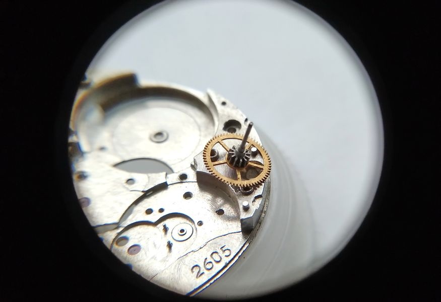 Vostok 2605 movement dial side through loupe with center wheel placed first in main plate departing from standard sequence