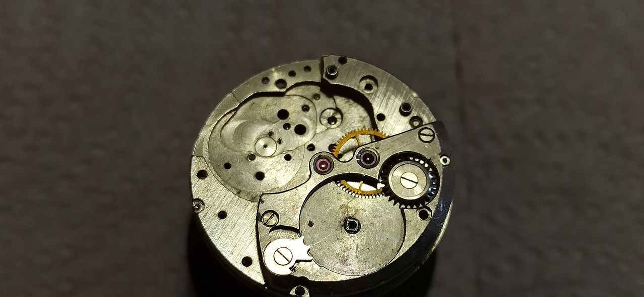 Reassembled movement with the combined bridge spanning barrel, central wheel and seconds arbor