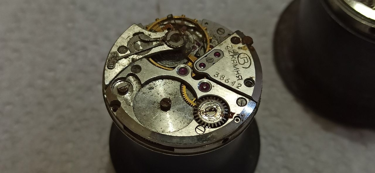 Rough but complete donor 2809 movement resting beside a case ring