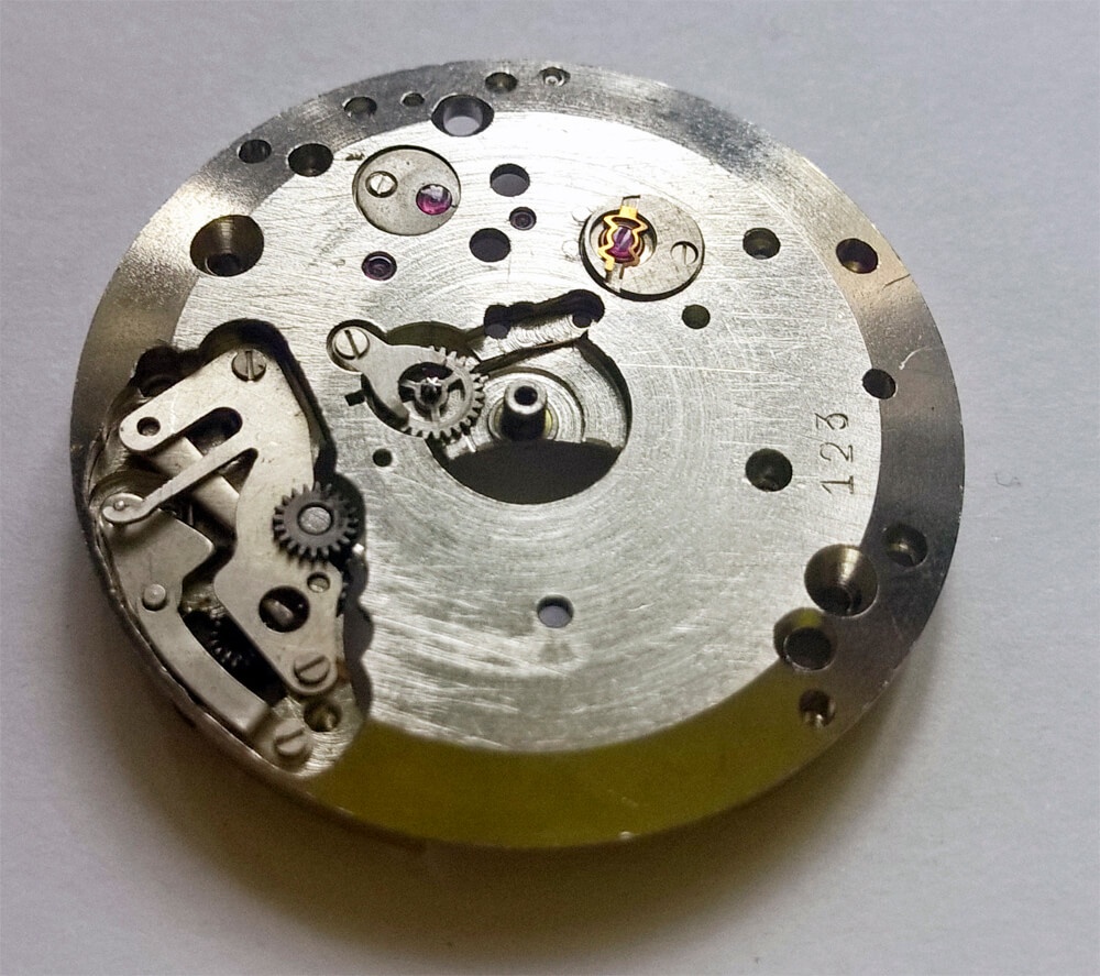 Dial-side reference view of the motion work showing the intermediate, minute and hour wheels