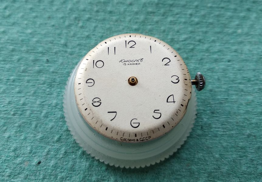 The hour, minute and seconds hands being refitted to the dial