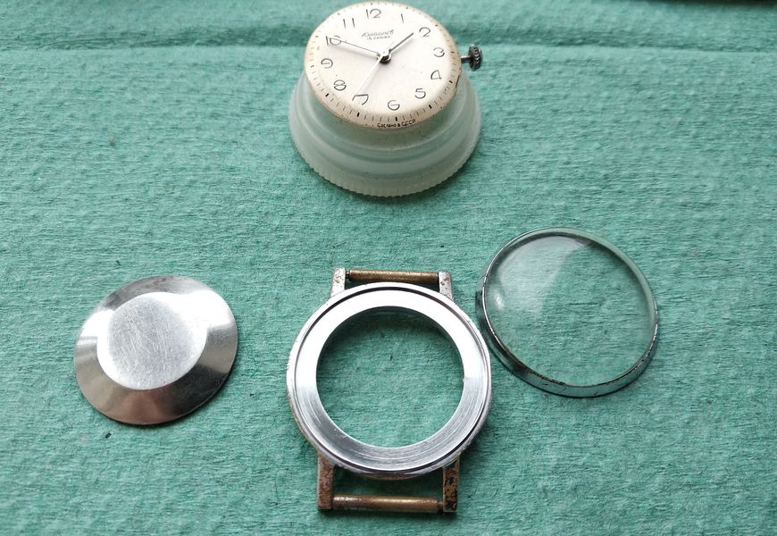 The serviced movement being lowered back into the watch case