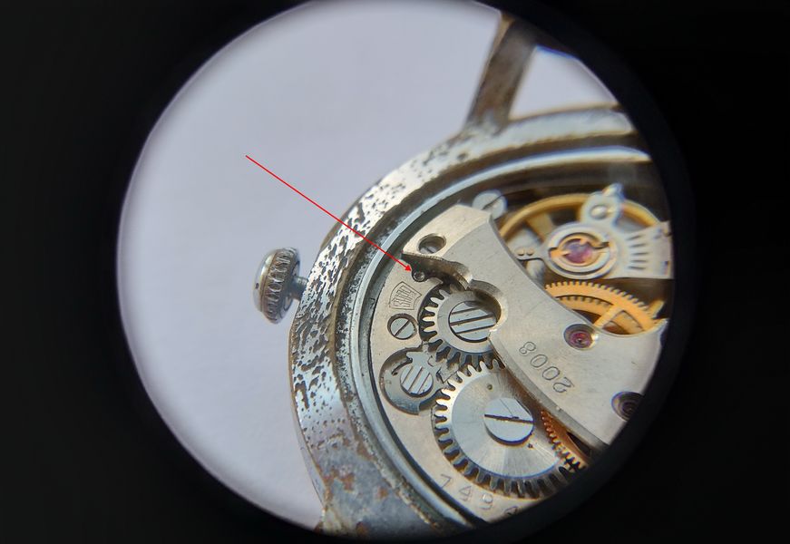 The concealed stem-release button on the movement being indicated with a tool