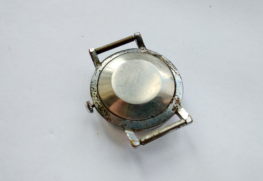 Rear three-quarter view of the chrome watch case showing the convex domed snap-on case back