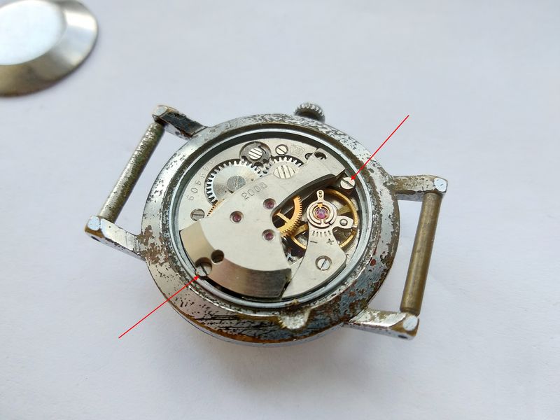 Movement retaining screws in the case being pointed out before removal