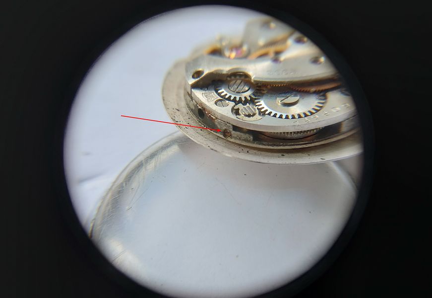 Dial-foot retaining screws on the side of the movement being loosened with a screwdriver