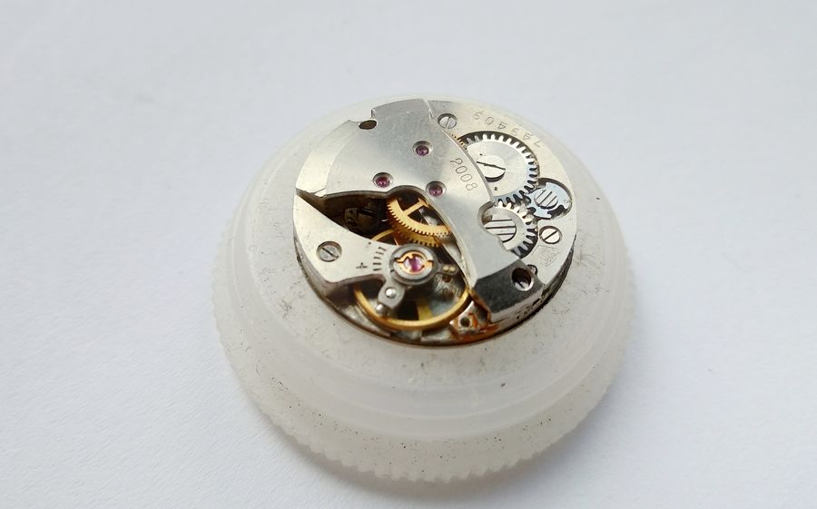 Movement flipped to the bridge side with the balance and cock being removed