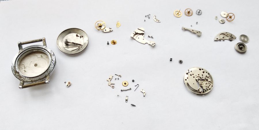 The full set of disassembled movement components spread out on the bench