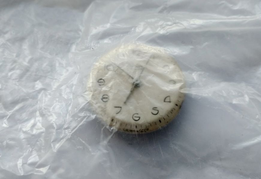 The dial covered with a sheet of thin protective film before the hands are removed