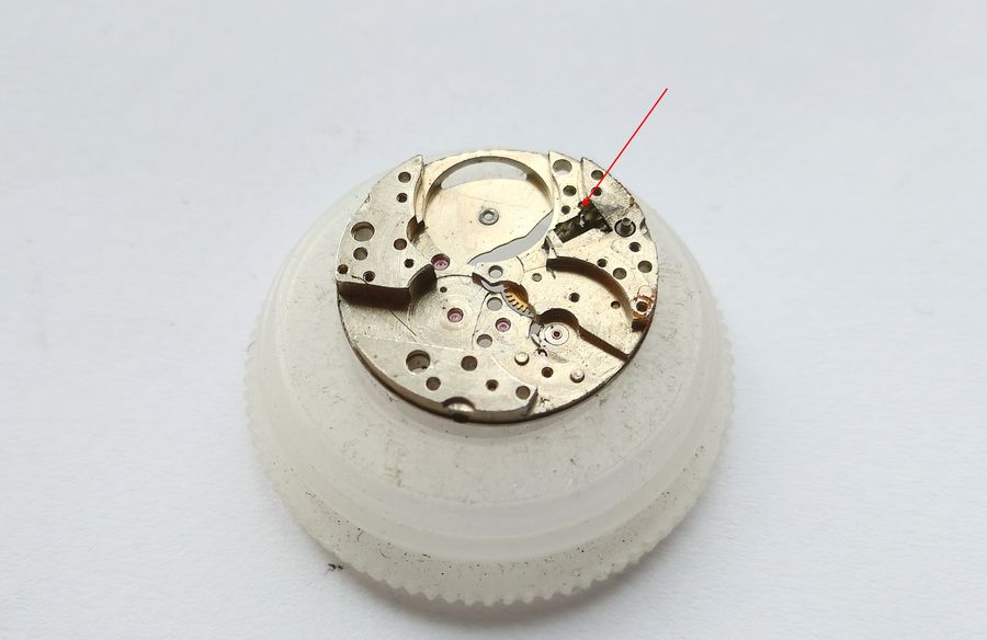 The sliding clutch and winding pinion withdrawn through the opening in the plate