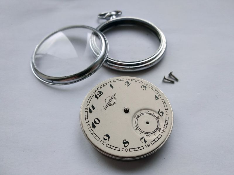 Dial fixing being released, held by three screws engaging the dial feet