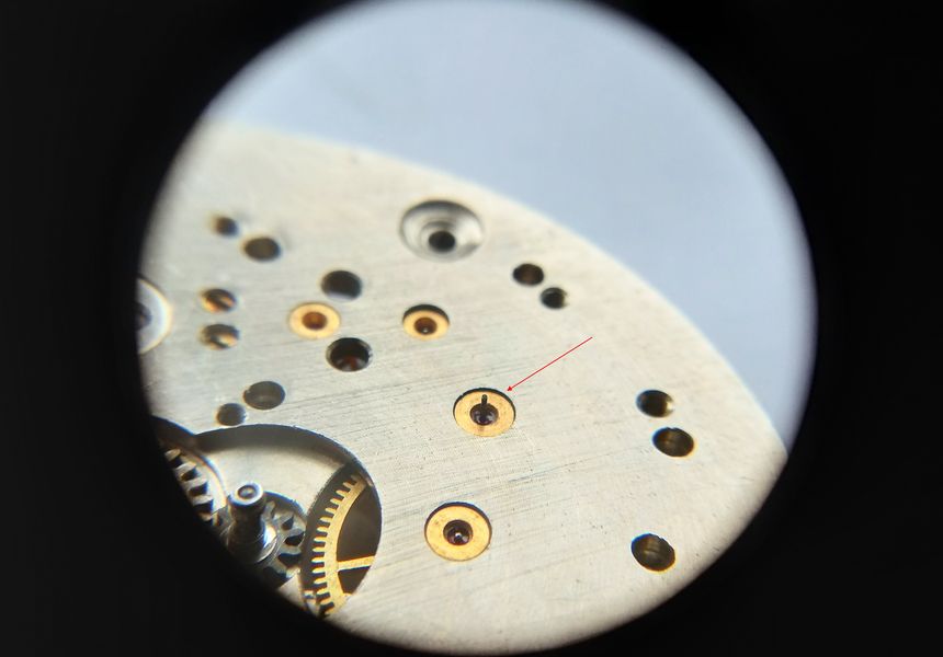 The vulnerable seconds-wheel pivot that must be protected during handling