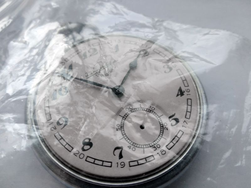 The three removed hands of the pocket watch laid out