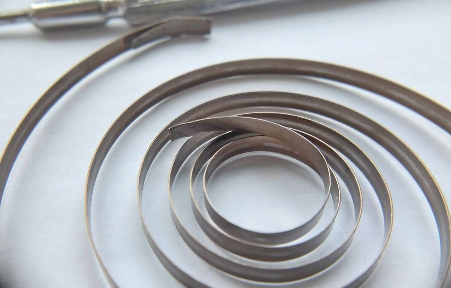 Mainspring with its inner loop broken off at the barrel arbor hook, the classic K-43 failure