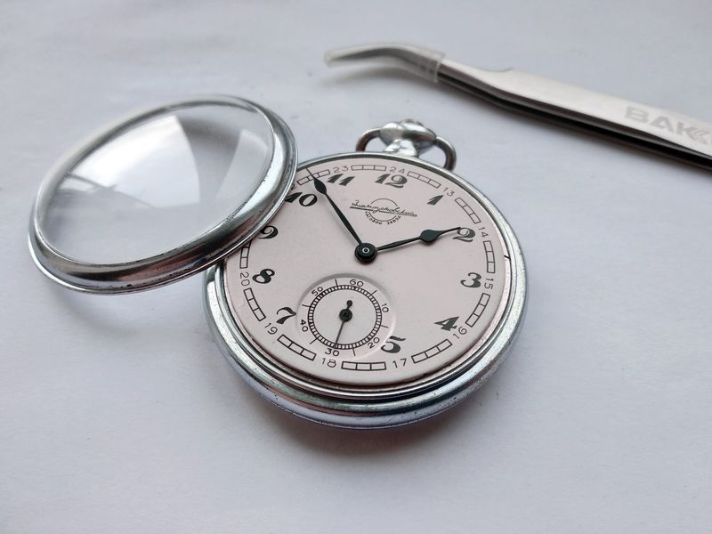 Hands being lifted from the dial through a protective film with curved tweezers